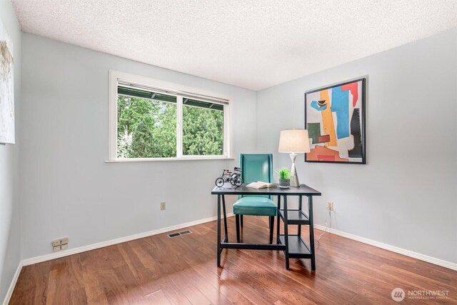 home office with baseboards, a textured ceiling, and wood finished floors