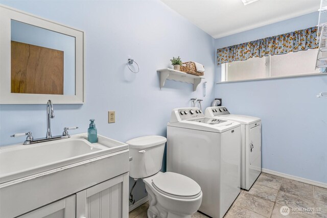 bathroom featuring separate washer and dryer, baseboards, vanity, and toilet