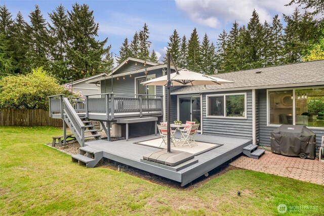 back of house with fence, a deck, a shingled roof, a yard, and stairway