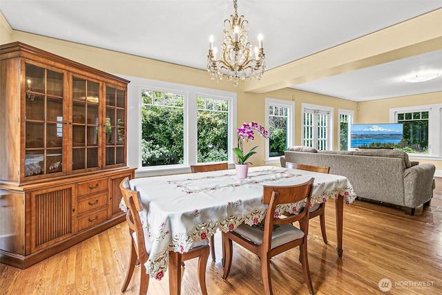 dining space featuring light wood-style floors and a notable chandelier