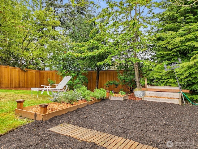 view of yard with a fenced backyard and a garden