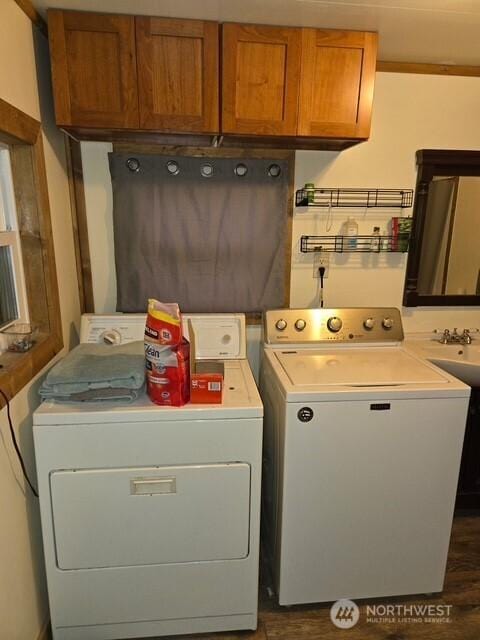 clothes washing area with washer and clothes dryer, cabinet space, and dark wood finished floors