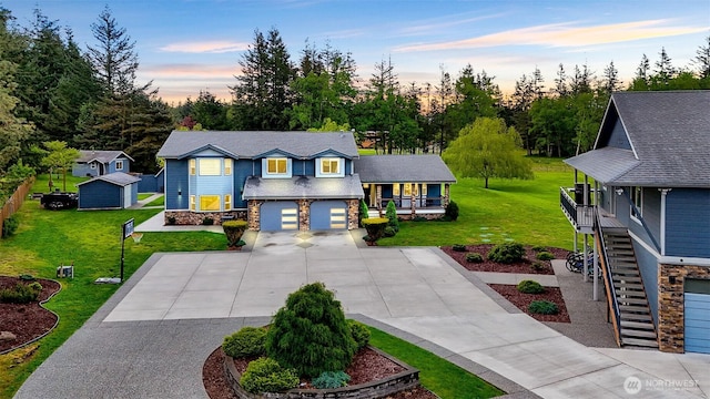 view of front of home featuring a yard, stone siding, and concrete driveway