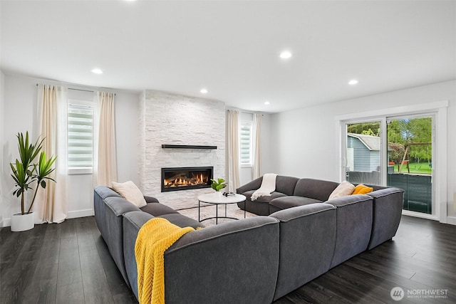 living room featuring recessed lighting, baseboards, a fireplace, and dark wood-style flooring