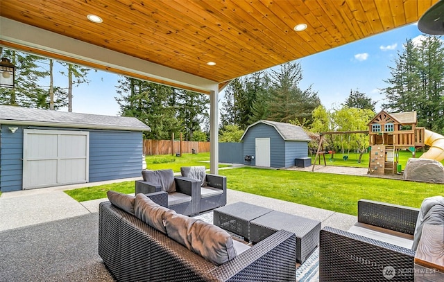 view of patio featuring fence, a shed, outdoor lounge area, an outbuilding, and a playground