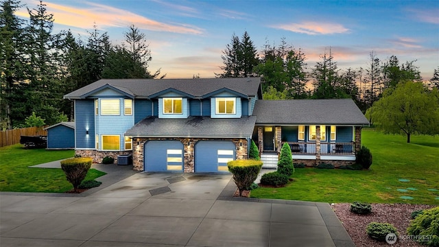 view of front facade featuring a porch, an attached garage, driveway, and a front lawn