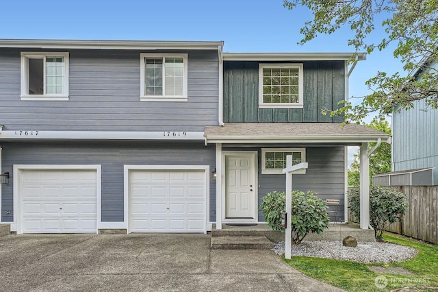 view of front of home featuring a garage, fence, board and batten siding, and concrete driveway