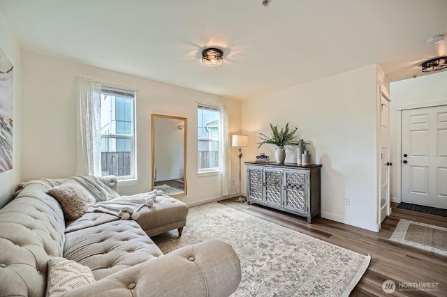 living area with baseboards and wood finished floors