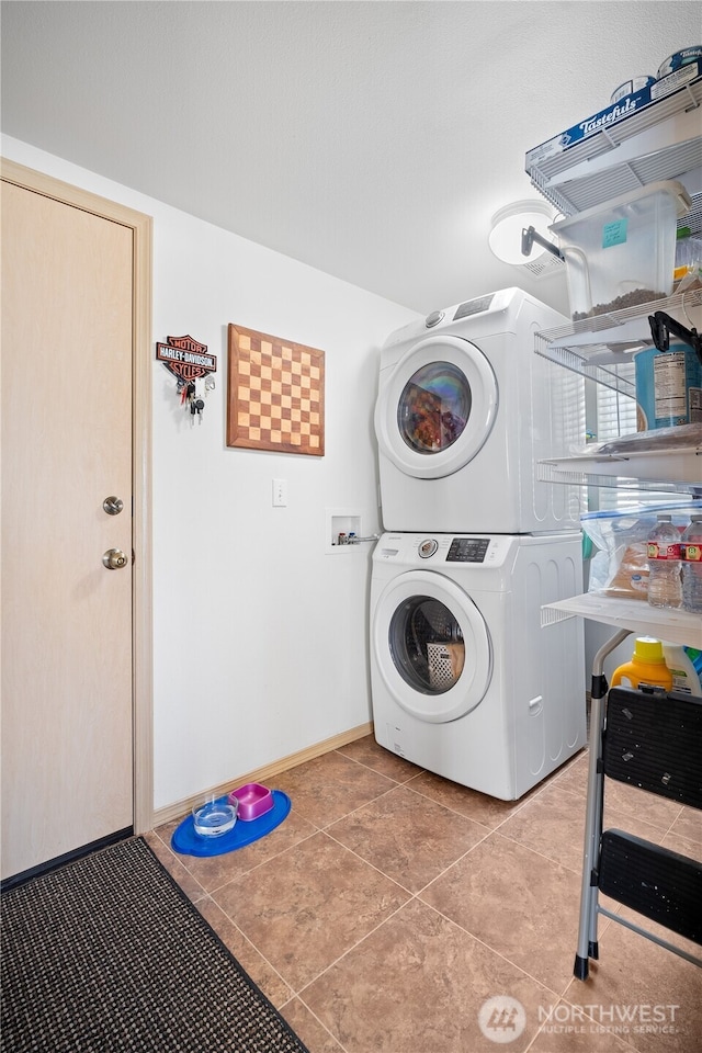 1810 Johnson Ave, Dupont, WA 98327 - clothes washing area featuring baseboards, laundry area, stacked washer / drying machine, and light tile patterned flooring