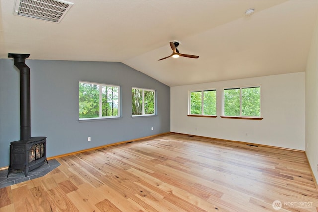 511 104th Ln SE, Olympia, WA 98501 - unfurnished living room with a ceiling fan, a wood stove, wood finished floors, lofted ceiling, and baseboards