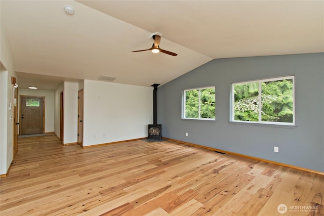 511 104th Ln SE, Olympia, WA 98501 - unfurnished living room with a wood stove, light wood-style floors, ceiling fan, lofted ceiling, and baseboards