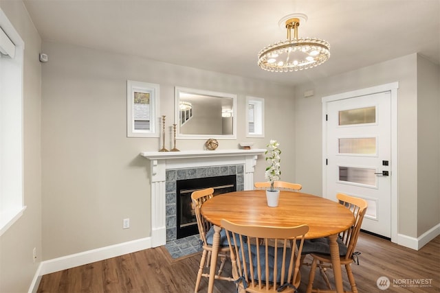 6369 23rd Ave SW, Seattle, WA 98106 - dining space featuring baseboards, a fireplace, wood finished floors, and a notable chandelier