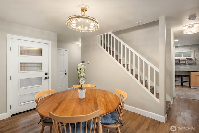 6369 23rd Ave SW, Seattle, WA 98106 - dining space with stairway, baseboards, an inviting chandelier, and wood finished floors