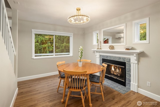 6369 23rd Ave SW, Seattle, WA 98106 - dining space featuring baseboards, a notable chandelier, a wall unit AC, and a tiled fireplace