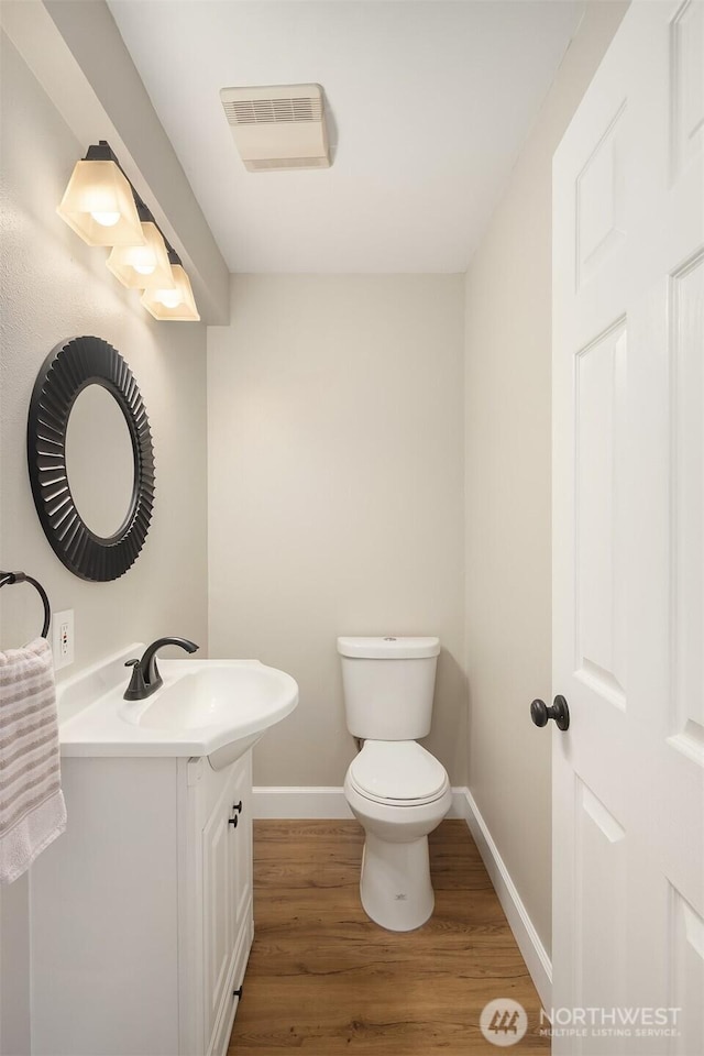 6369 23rd Ave SW, Seattle, WA 98106 - bathroom featuring visible vents, vanity, wood finished floors, toilet, and baseboards