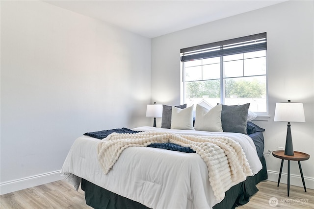 bedroom with baseboards and wood finished floors