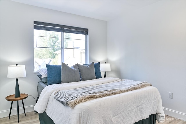 bedroom with baseboards and light wood finished floors