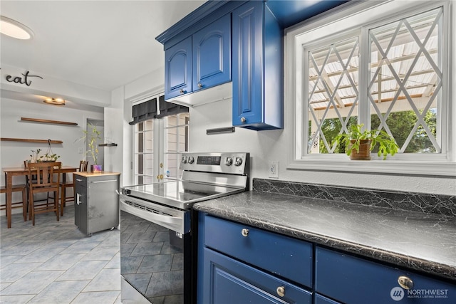 5808 241st St SW, Mountlake Terrace, WA 98036 - kitchen with a healthy amount of sunlight, dark countertops, blue cabinets, and electric stove