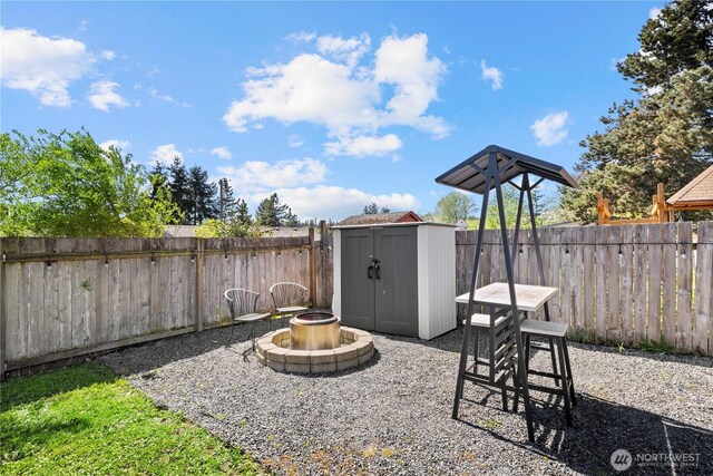5808 241st St SW, Mountlake Terrace, WA 98036 - view of patio featuring a fenced backyard, an outdoor structure, an outdoor fire pit, and a shed