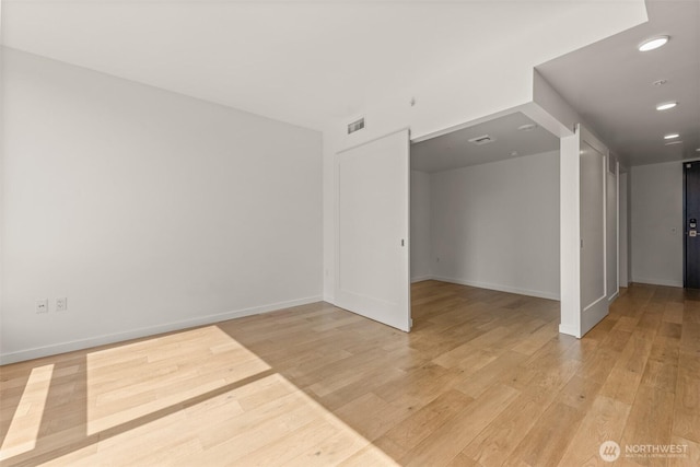 unfurnished room featuring light wood-type flooring, baseboards, and recessed lighting