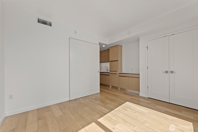 unfurnished bedroom with light wood finished floors and baseboards