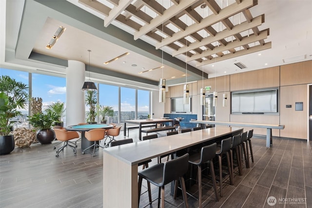 kitchen featuring a large island, wood tiled floors, modern cabinets, a kitchen breakfast bar, and a high ceiling