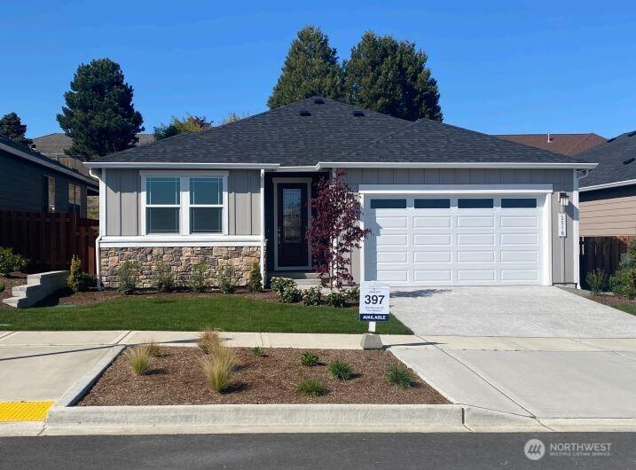 single story home with a garage, fence, stone siding, board and batten siding, and concrete driveway