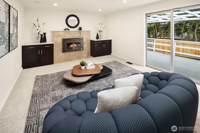 living room with a fireplace, baseboards, light carpet, and recessed lighting