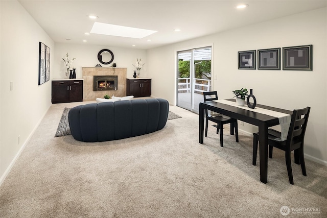 living area with recessed lighting, carpet, a fireplace, and a skylight
