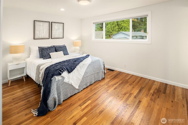 bedroom featuring baseboards, recessed lighting, wood finished floors, and visible vents