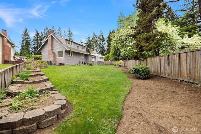 view of yard with central air condition unit and a fenced backyard