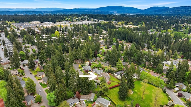 drone / aerial view with a residential view, a mountain view, and a wooded view