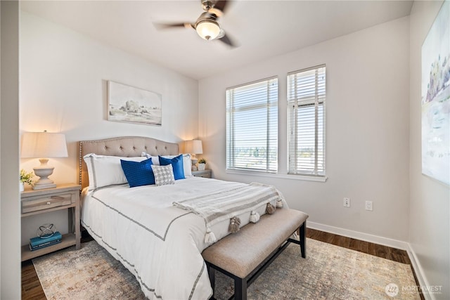 bedroom featuring ceiling fan, baseboards, multiple windows, and wood finished floors