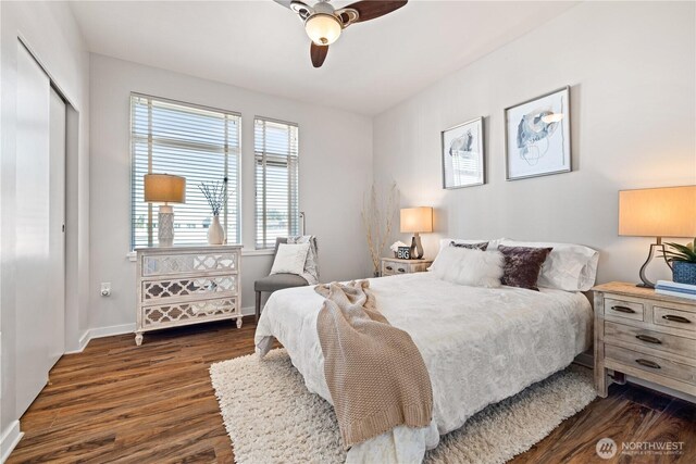 bedroom with a closet, baseboards, a ceiling fan, and dark wood-type flooring