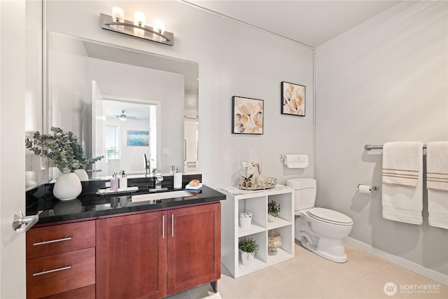 bathroom with vanity, toilet, tile patterned floors, a ceiling fan, and baseboards