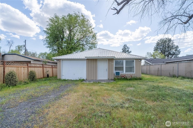 rear view of property with a fenced backyard, board and batten siding, a yard, and driveway