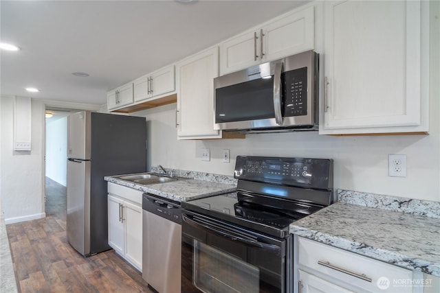 kitchen with stainless steel appliances, dark wood-style floors, a sink, and white cabinetry