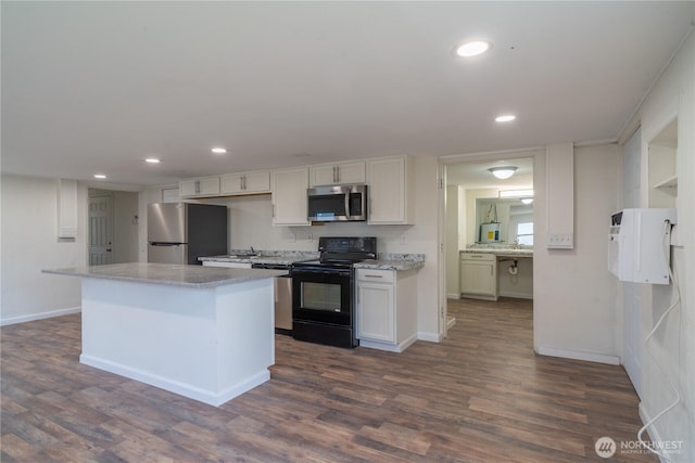 kitchen featuring recessed lighting, appliances with stainless steel finishes, a center island, and dark wood finished floors