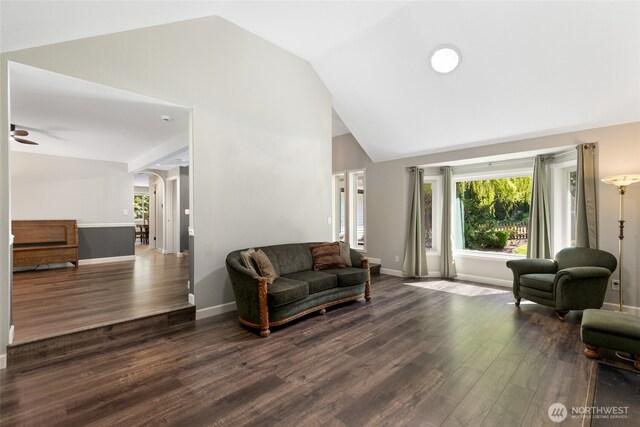 living room with a ceiling fan, baseboards, high vaulted ceiling, arched walkways, and dark wood finished floors