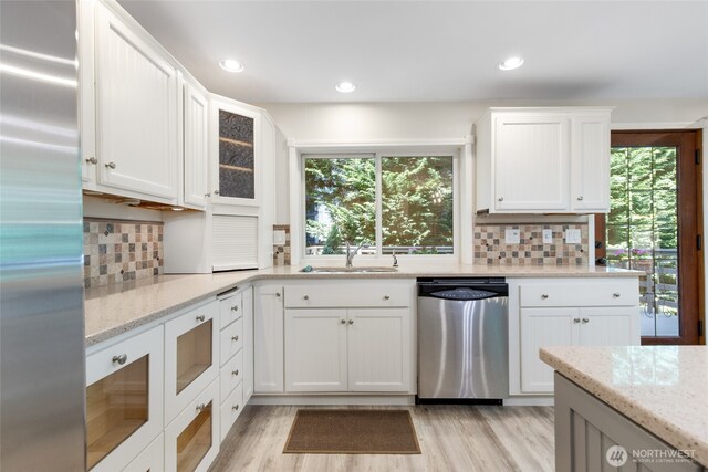 kitchen with a sink, white cabinetry, appliances with stainless steel finishes, and a wealth of natural light