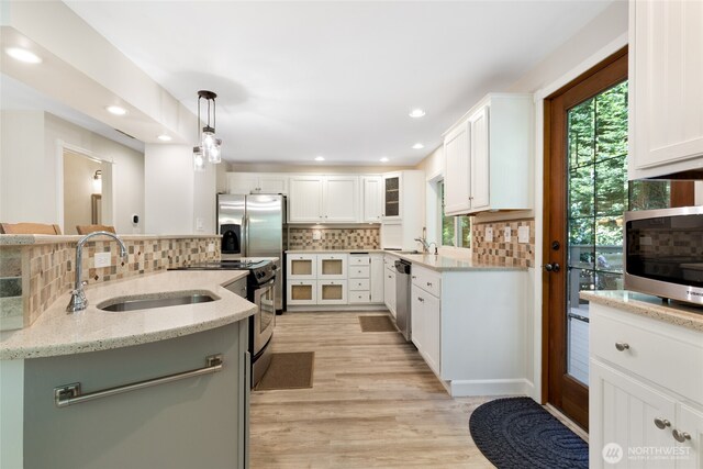 kitchen featuring stainless steel appliances, plenty of natural light, a sink, and tasteful backsplash