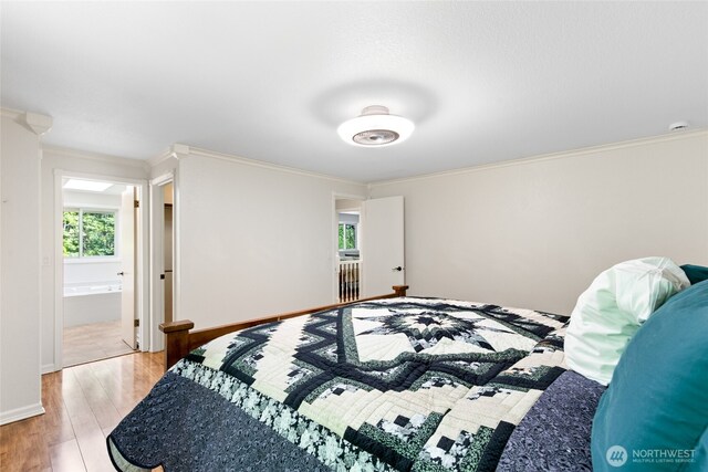 bedroom featuring light wood-style floors, ornamental molding, and baseboards