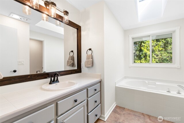 bathroom featuring baseboards, a garden tub, and vanity