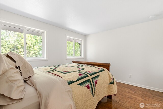 bedroom with baseboards and wood finished floors