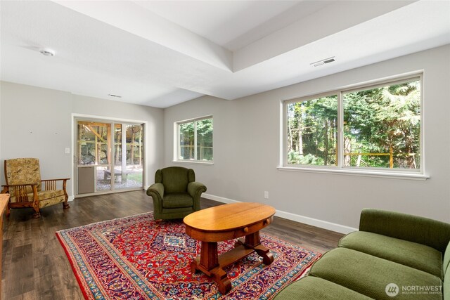 living room with visible vents, baseboards, and wood finished floors