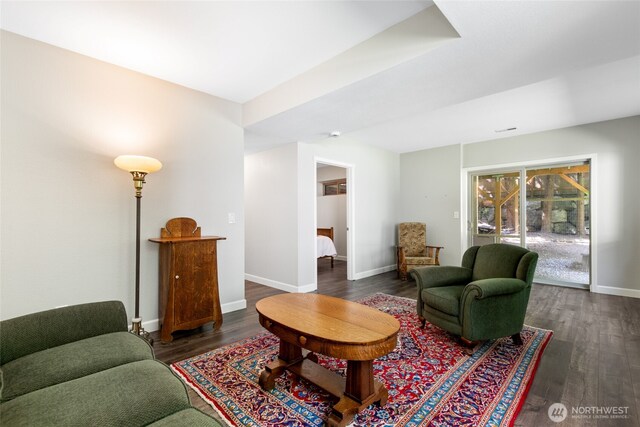 living area with baseboards and dark wood-style flooring