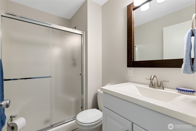 bathroom with vanity, toilet, and a stall shower