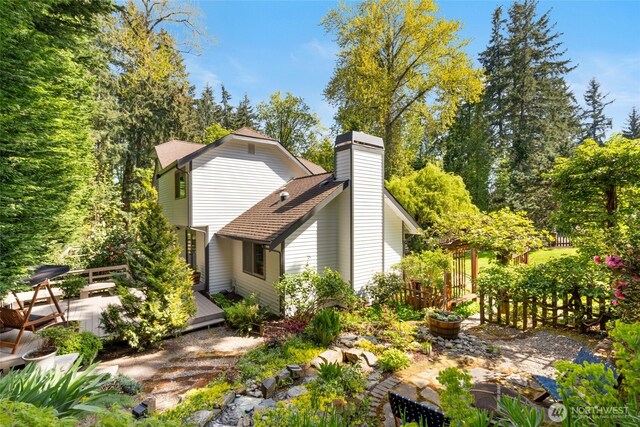 rear view of house with a wooden deck and a chimney