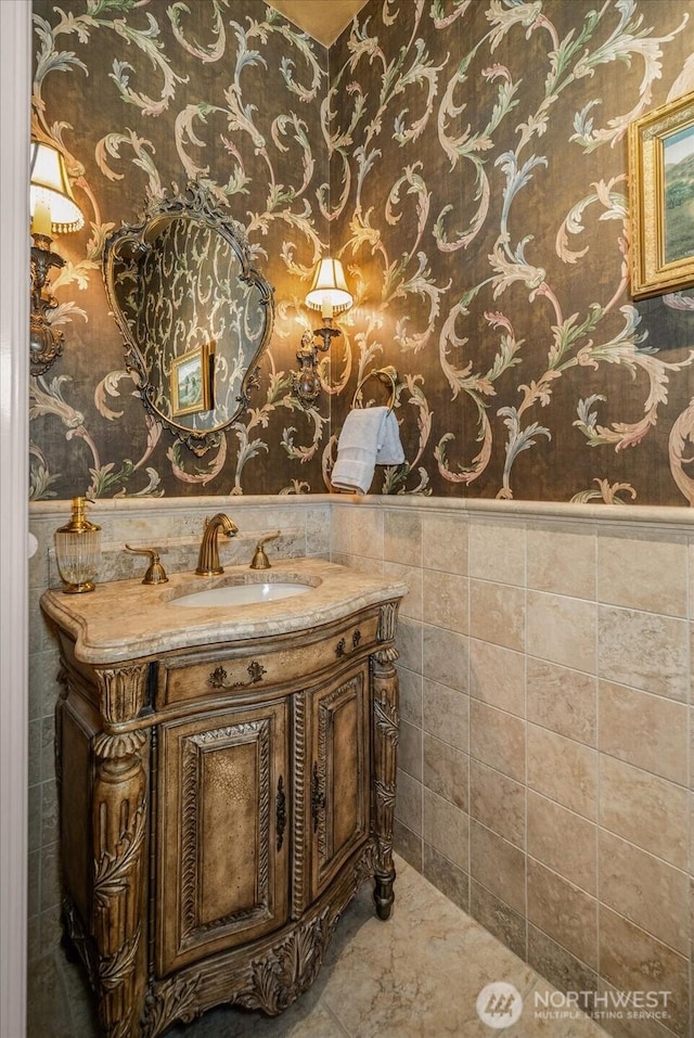 1909 E Pinecrest Rd, Spokane, WA 99202 - bathroom featuring wallpapered walls, wainscoting, vanity, and tile walls