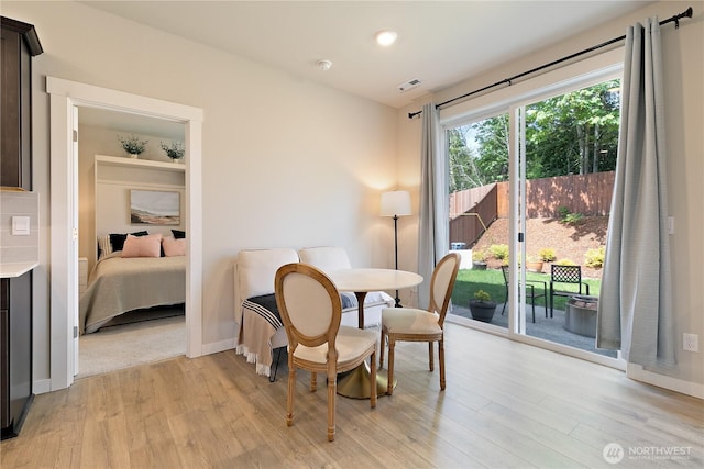 dining space featuring light wood-style floors, baseboards, and visible vents